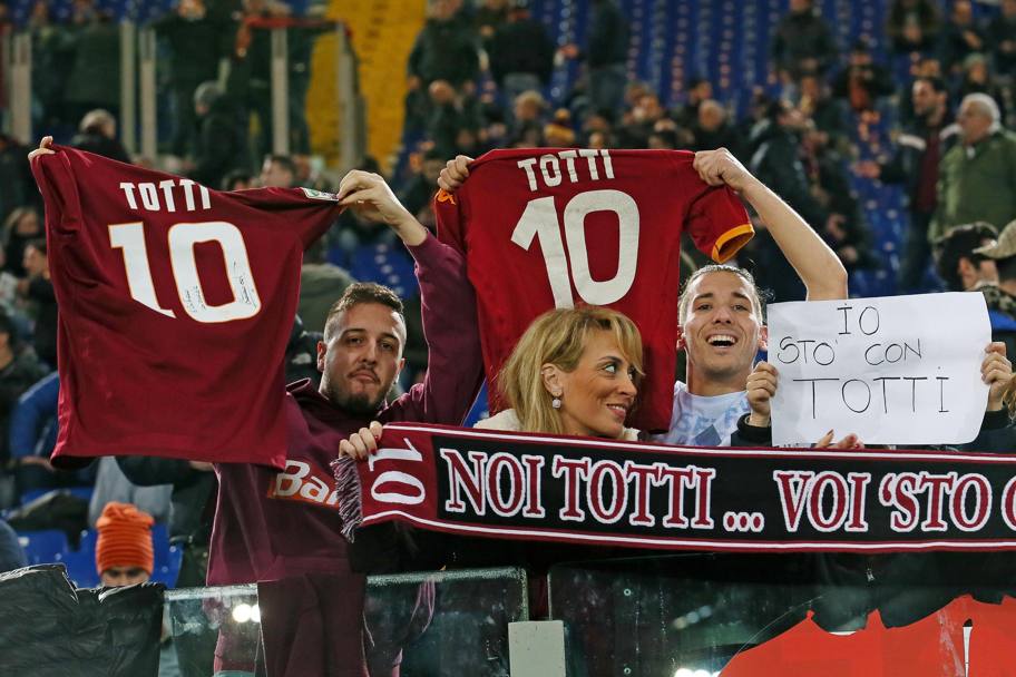 I tifosi della Roma mostrano sciarpe e maglie a difesa del capitano giallorosso Francesco Totti. Ansa